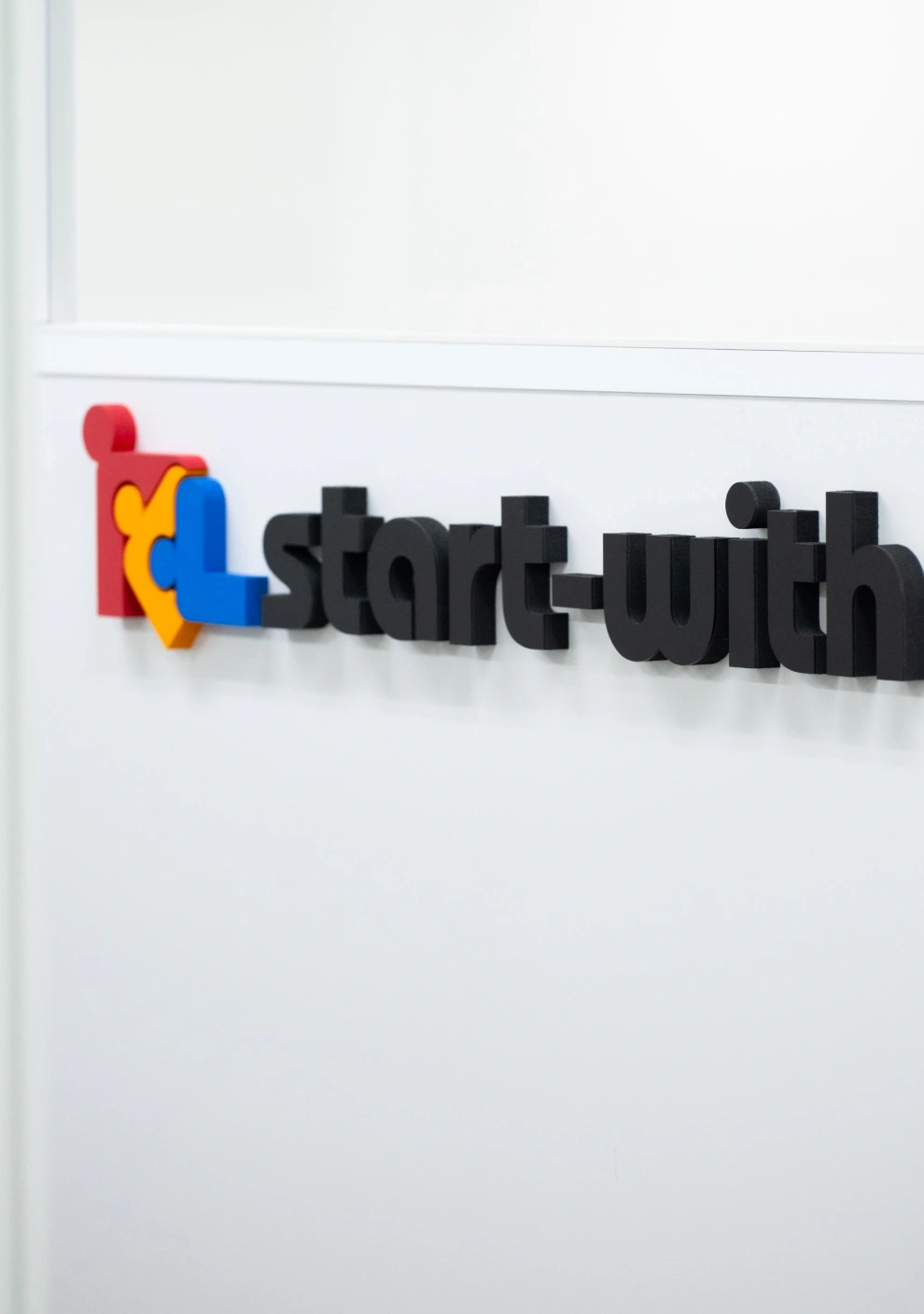 オフィスの壁に取り付けられたstart-withの立体ロゴ