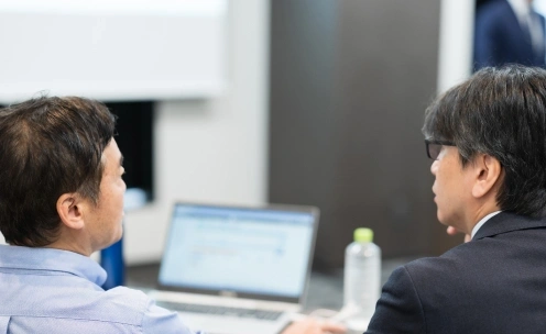 2人が並んでノートPCの画面を確認している様子