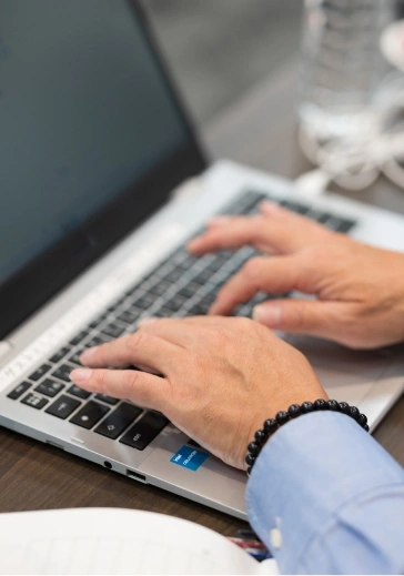 ノートPCのキーボードを両手で打っているクローズアップ