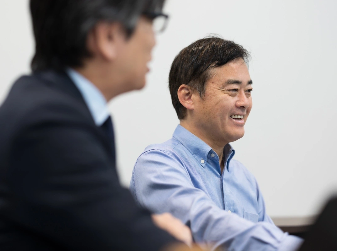 会議中に笑顔で話を聞いている男性のクローズアップ