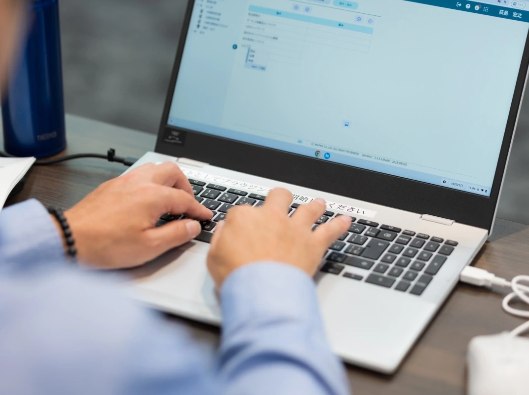 ノートPCのキーボードを操作している手元のクローズアップ